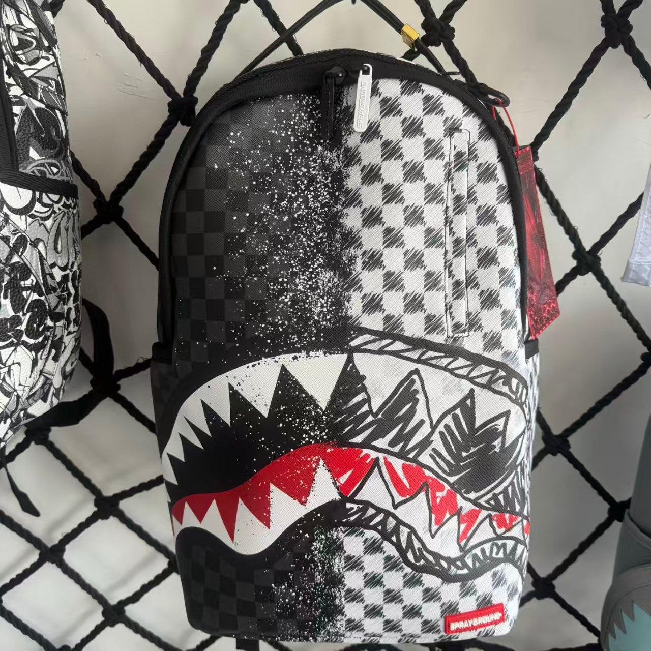 Urban Streetwear Backpack – Black & White Scribble Checkerboard with Shark Mouth and Splatter Design