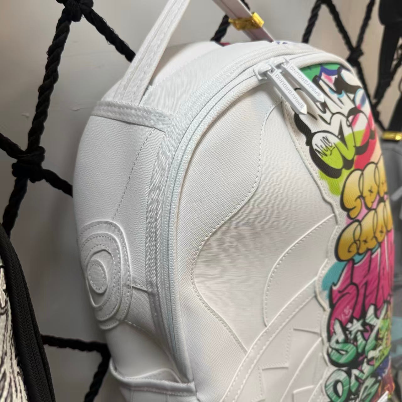 White Backpack with 3D Stitched Shark Mouth and Colorful Graffiti Splice Design