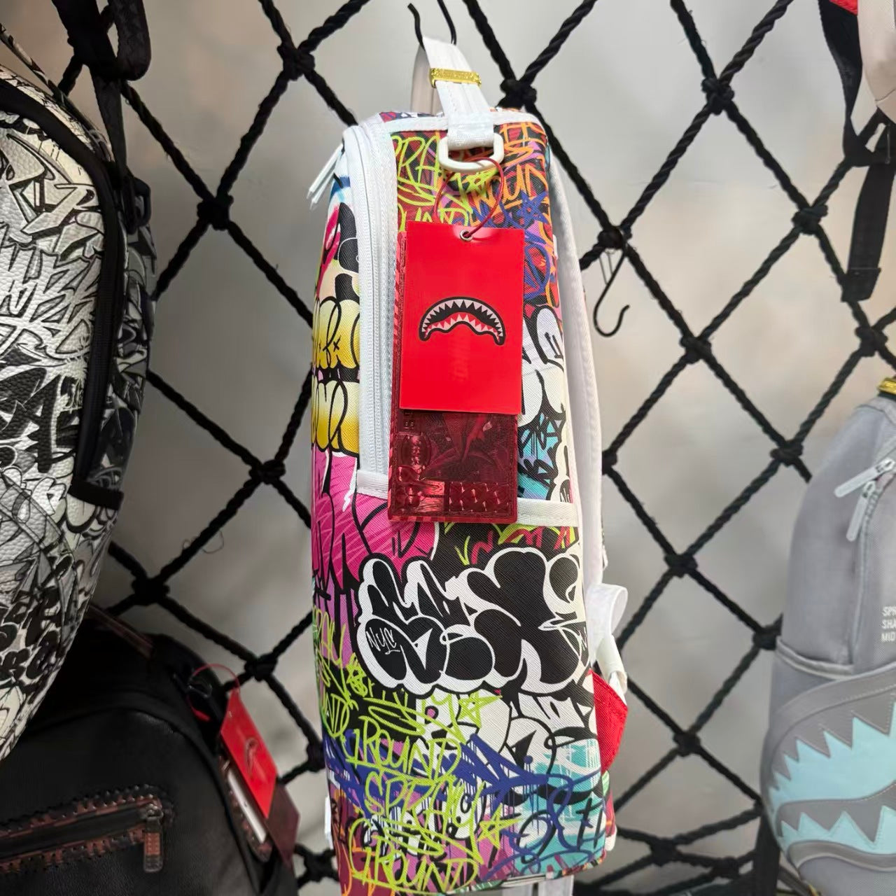 White Backpack with 3D Stitched Shark Mouth and Colorful Graffiti Splice Design