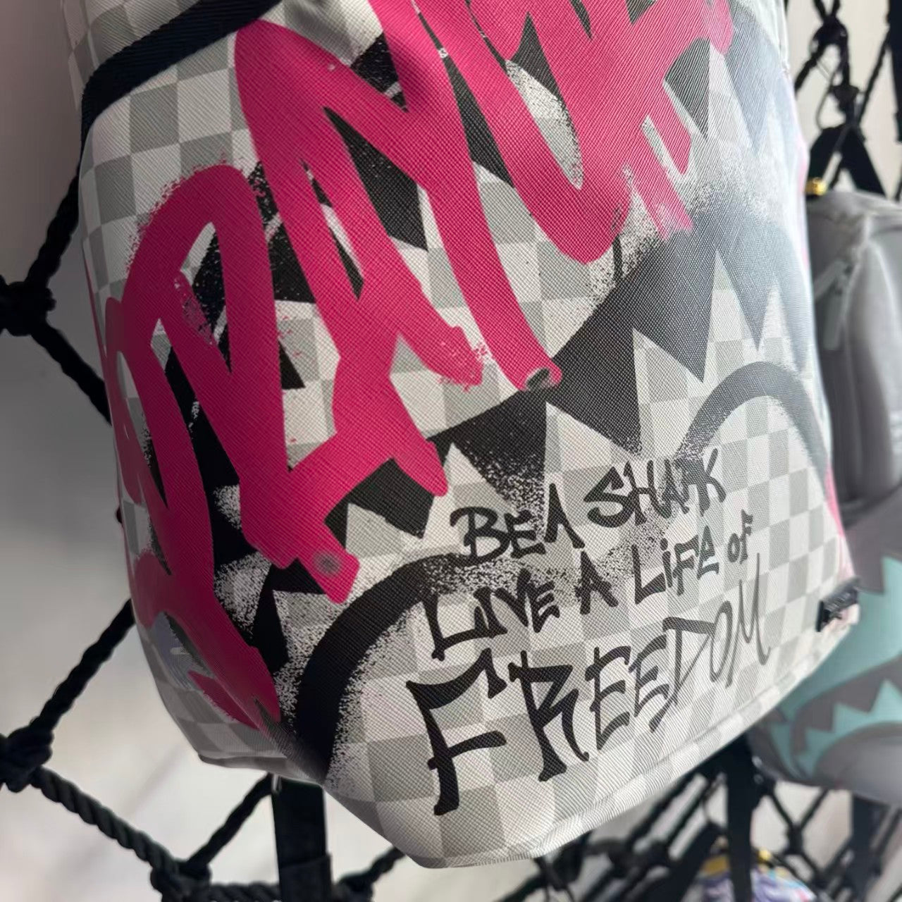 Pink Graffiti Splatter Streetwear Backpack - Grey Checkerboard with Handwritten Slogans and Shark Mouth Design