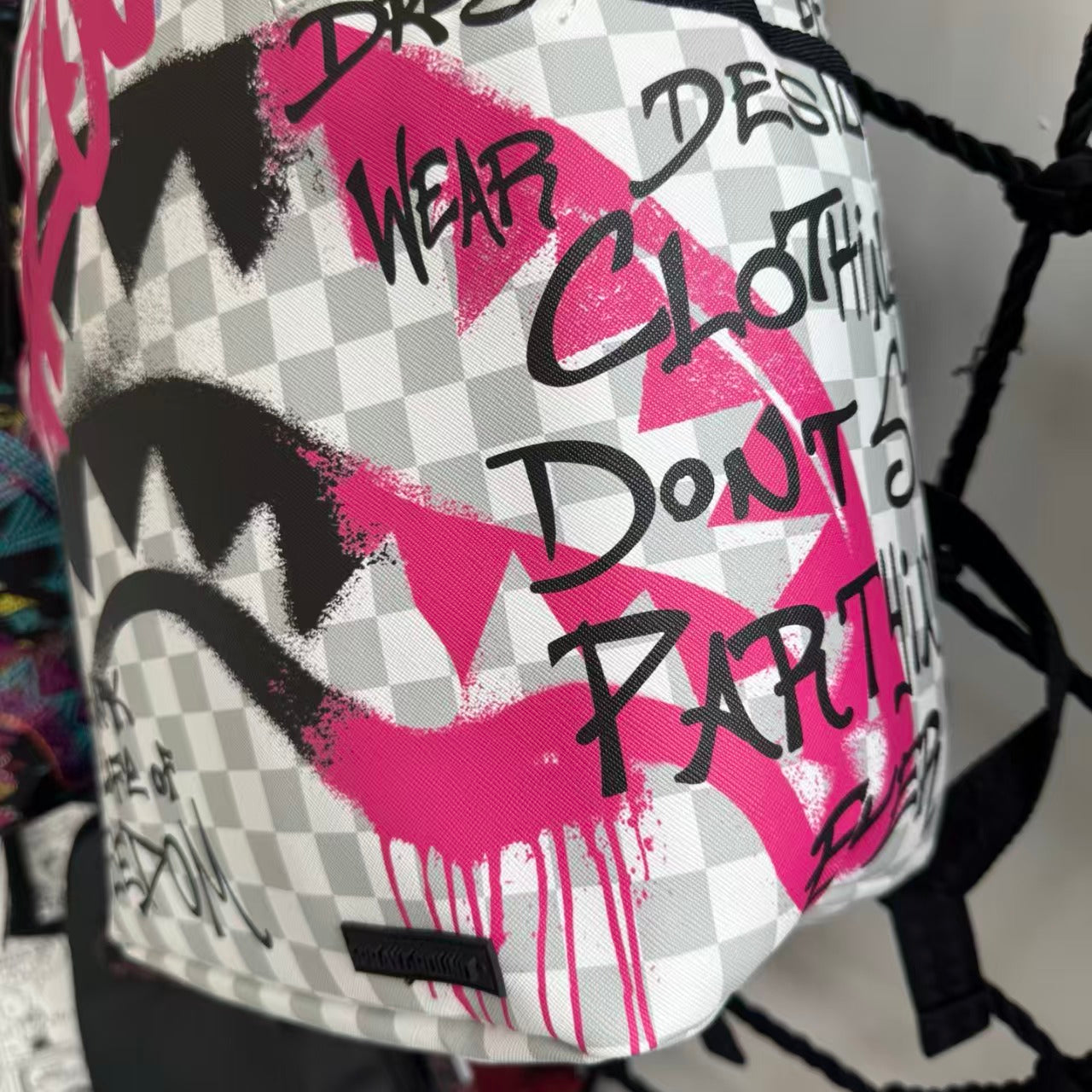Pink Graffiti Splatter Streetwear Backpack - Grey Checkerboard with Handwritten Slogans and Shark Mouth Design