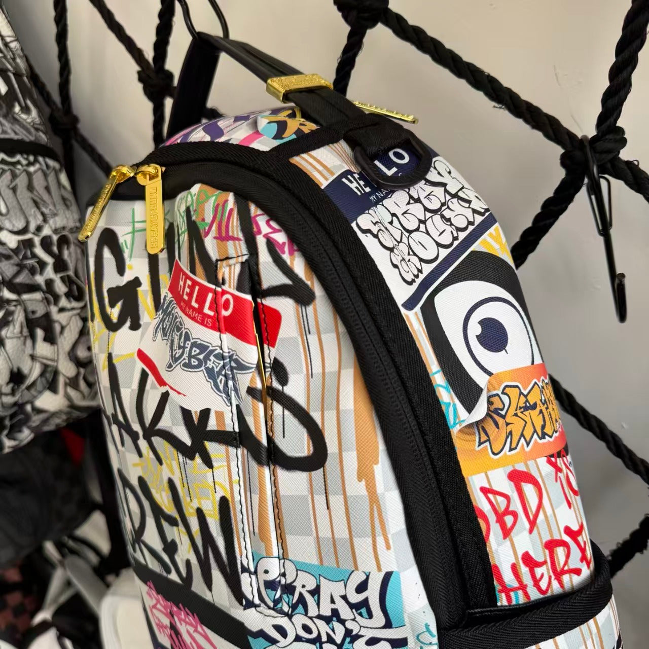 Streetwear Graffiti Collage Backpack - Light Checkerboard Base with Colorful Handwritten Lettering & Sticker Design